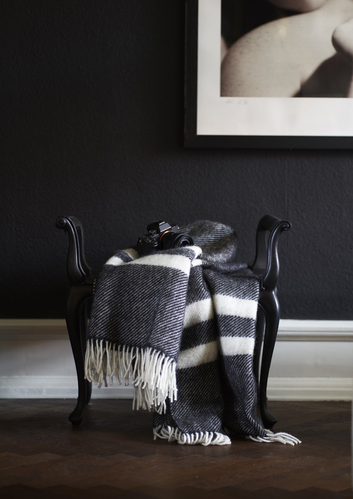 Klippan: Wolldecke Gotland Stripe in Schwarz über einem Sessel